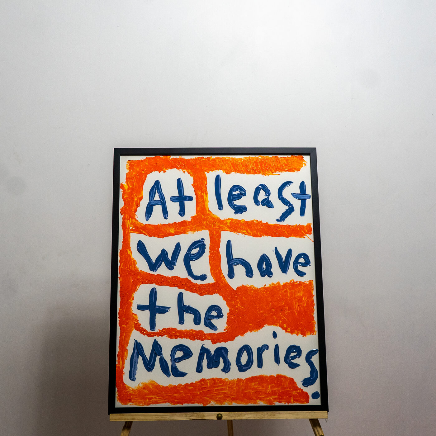 Painting reading At least we have the memories, in navy on orange