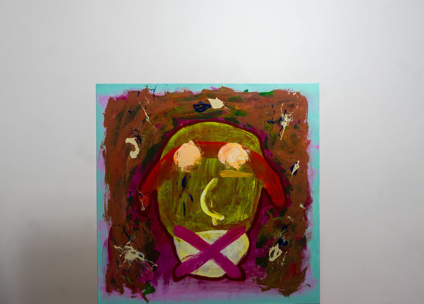 Abstracted face painting in green, red, and magenta