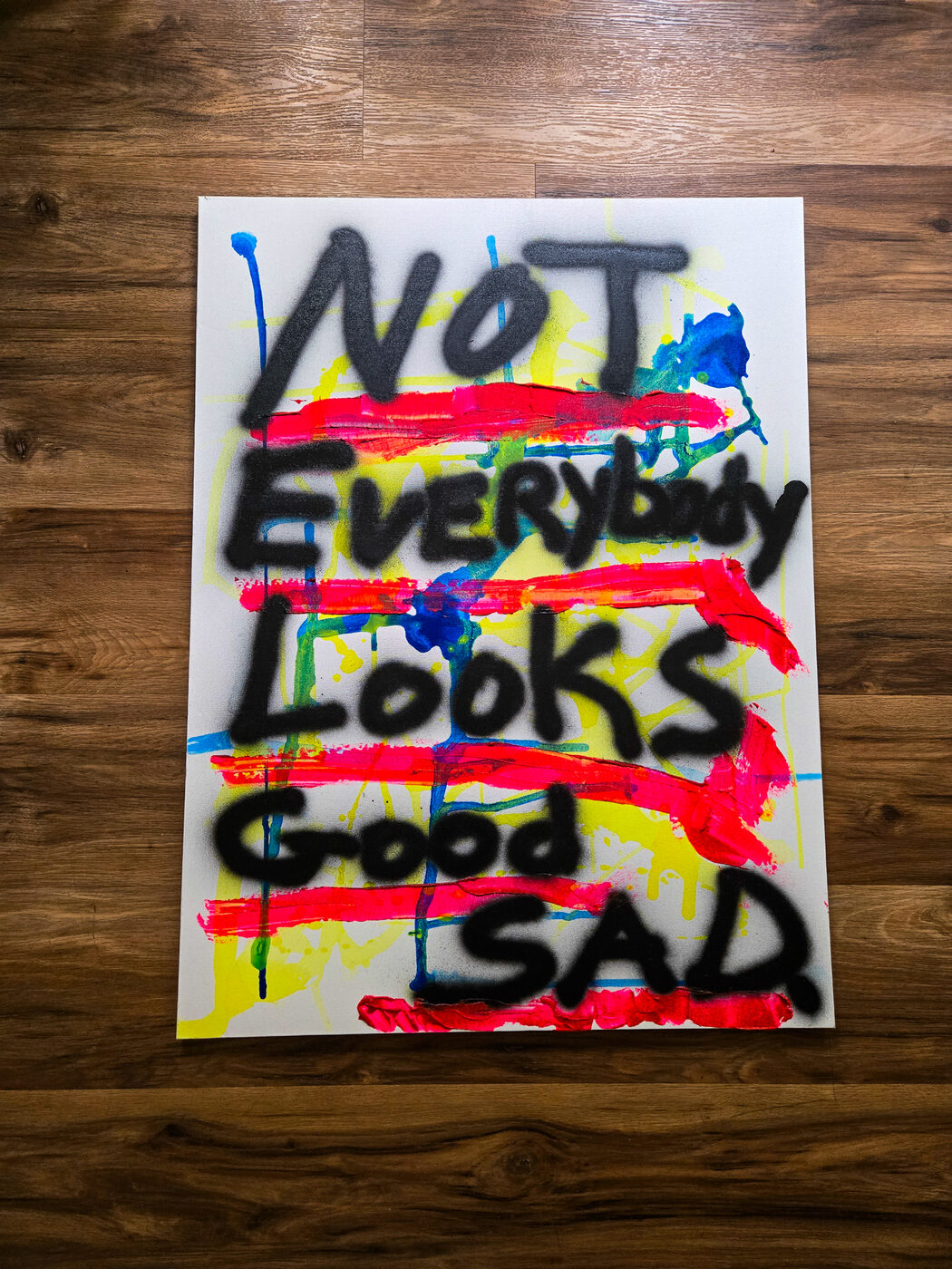 Painting with layered black text over a colorful abstract background